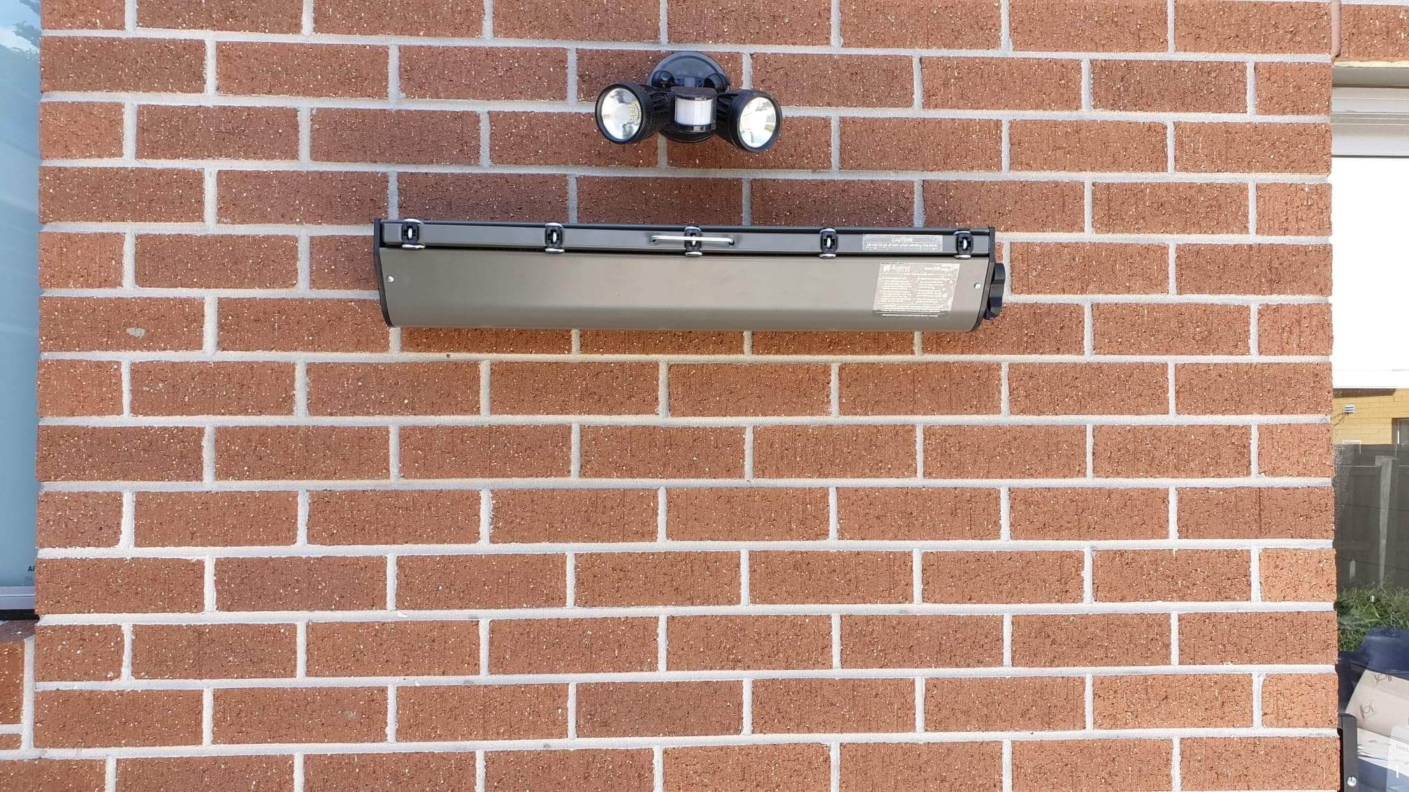 Wall mounted retractable austral clothesline installation onto brick wall at home in Caulfield, Melbourne.