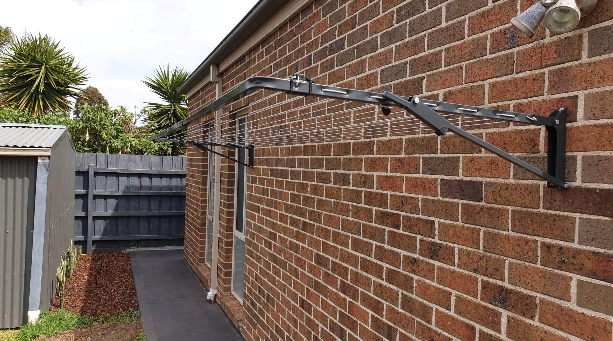 Folding clothesline installation onto brick wall in Melbourne suburb of Greenvale.